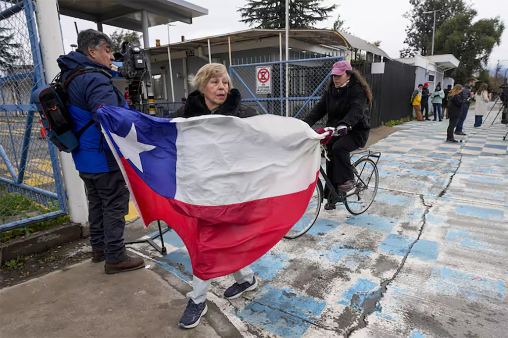 Una mujer sostiene una bandera chilena en apoyo a los mineros frente a las oficinas de Codelco, operadora de la mina de cobre El Teniente, donde un derrumbe mató a un trabajador y atrapó a otros cinco bajo tierra, deteniendo las operaciones en Rancagua, Chile, el sábado 2 de agosto de 2025.